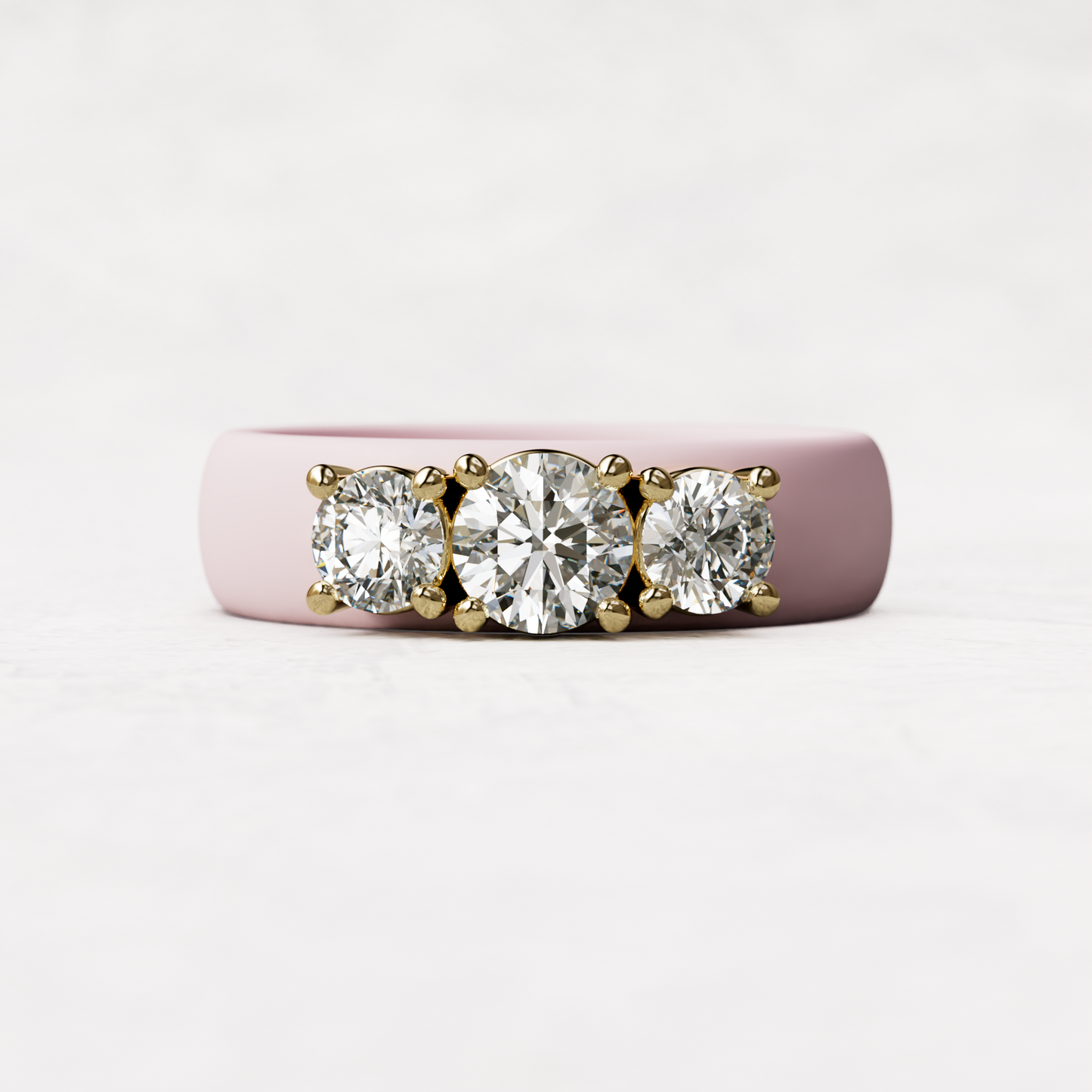 Three stone hot pink silicone diamond ring with one half carat round diamond and two quarter carat round diamonds set in 14 karat gold