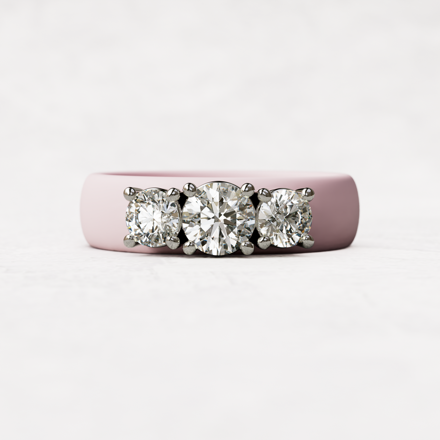 Three stone pink silicone diamond ring with one half carat round diamond and two quarter carat round diamonds set in 14 karat white gold