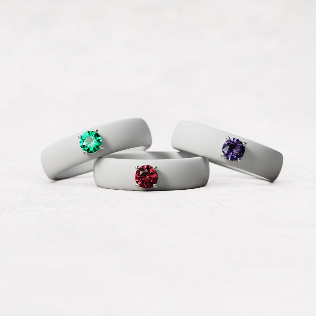 three birthstone rings with white silicone bands and natural gemstones