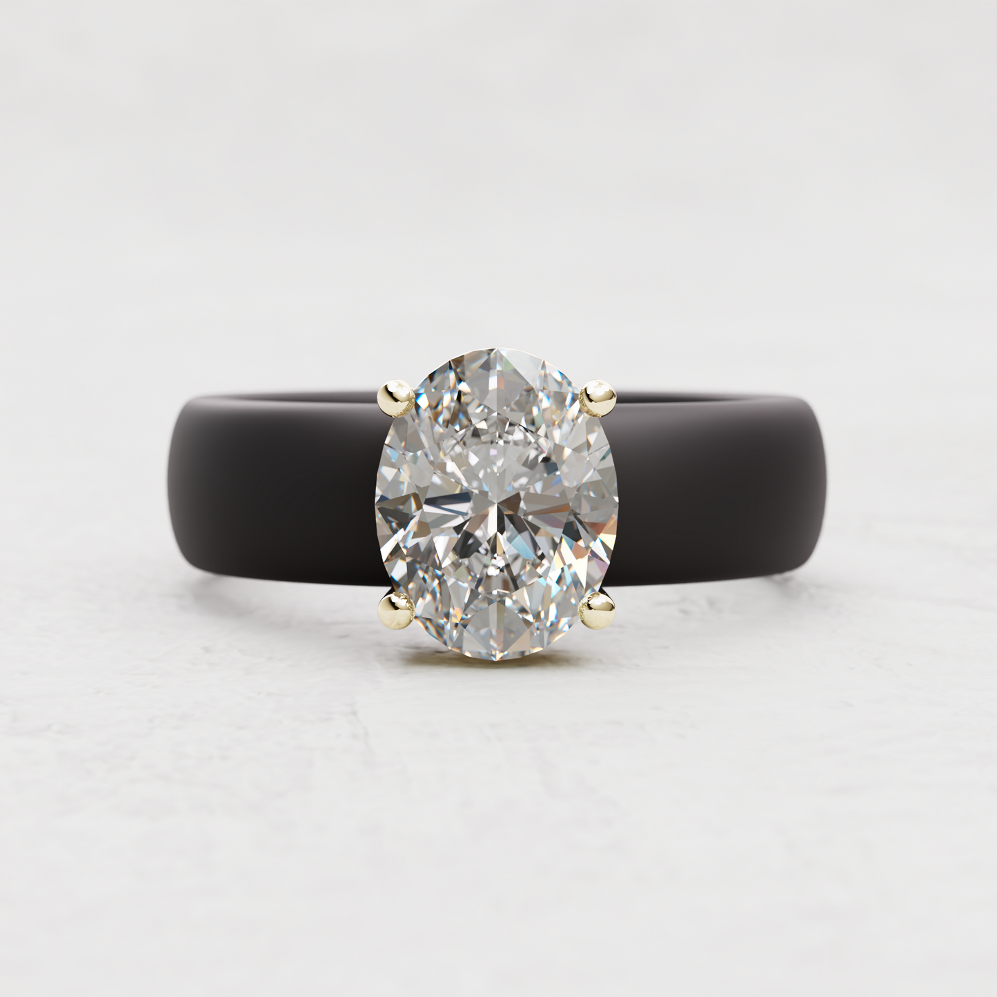 An oval-cut diamond ring with a matte black band and yellow gold prongs, centered on a light gray background.