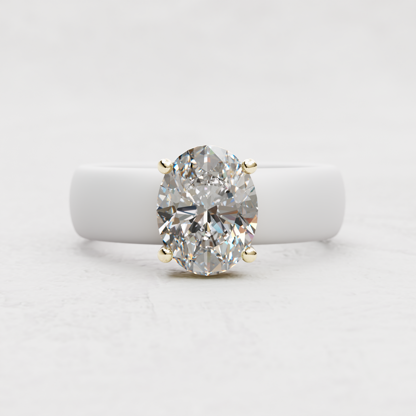 An oval-cut diamond ring in a four-prong yellow gold setting, displayed on a white ring stand against a light gray background.