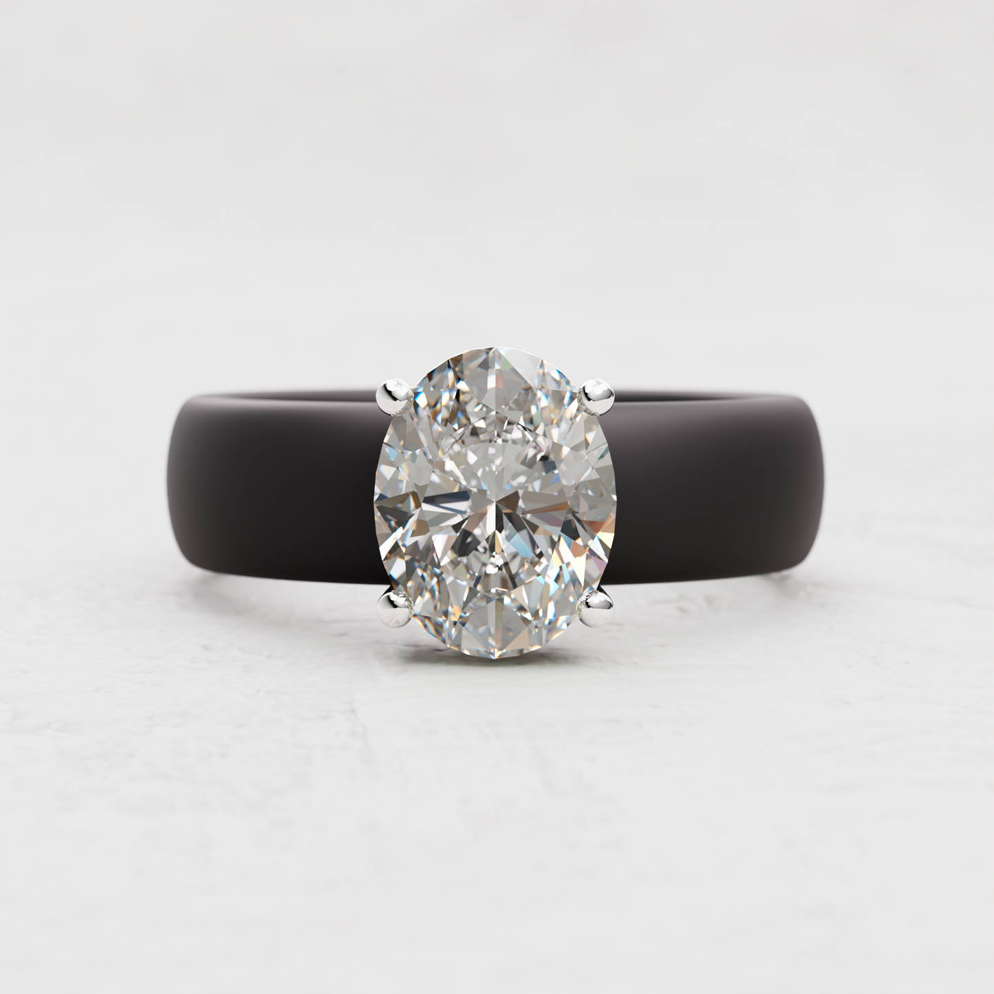 An oval-cut diamond ring with a matte black band and yellow gold prongs, centered on a light gray background.