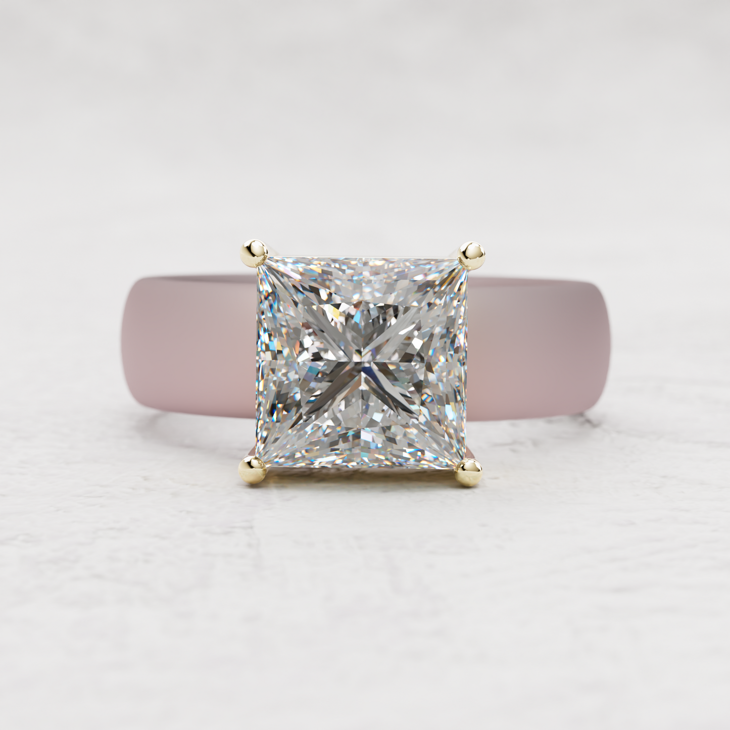 A princess-cut diamond ring with a yellow gold four-prong setting, displayed on a soft pink ring stand against a light gray textured background.