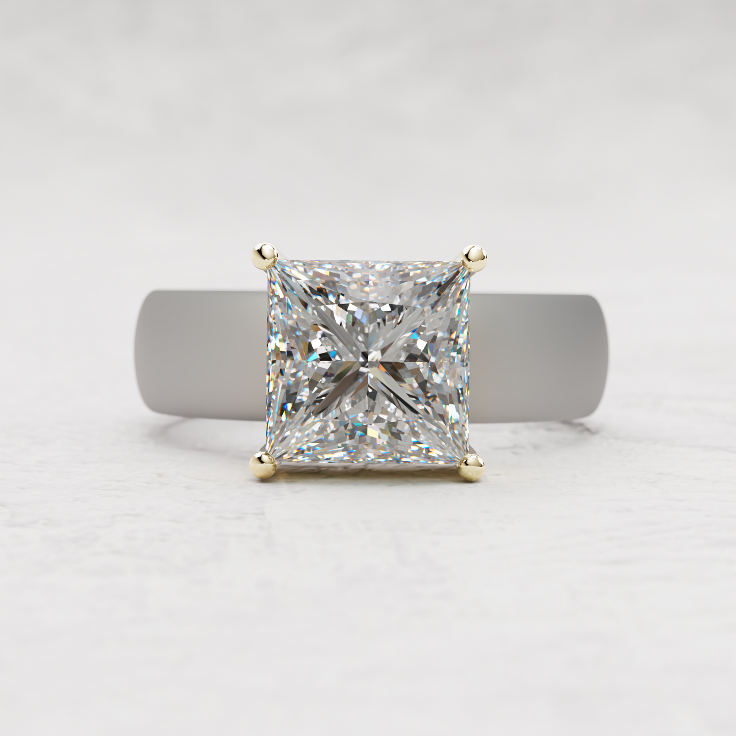 A princess-cut diamond ring in a yellow gold four-prong setting, displayed on a gray ring stand against a light gray textured background.