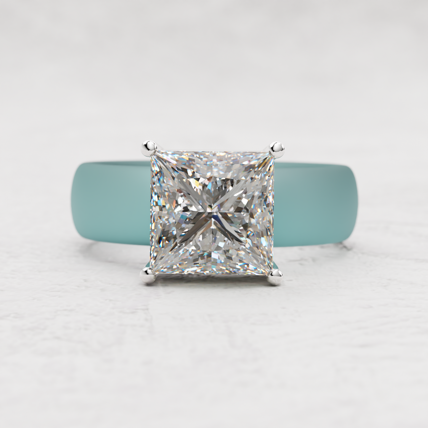 A princess-cut diamond ring with a silver four-prong setting, displayed on a light blue ring stand against a white textured background.