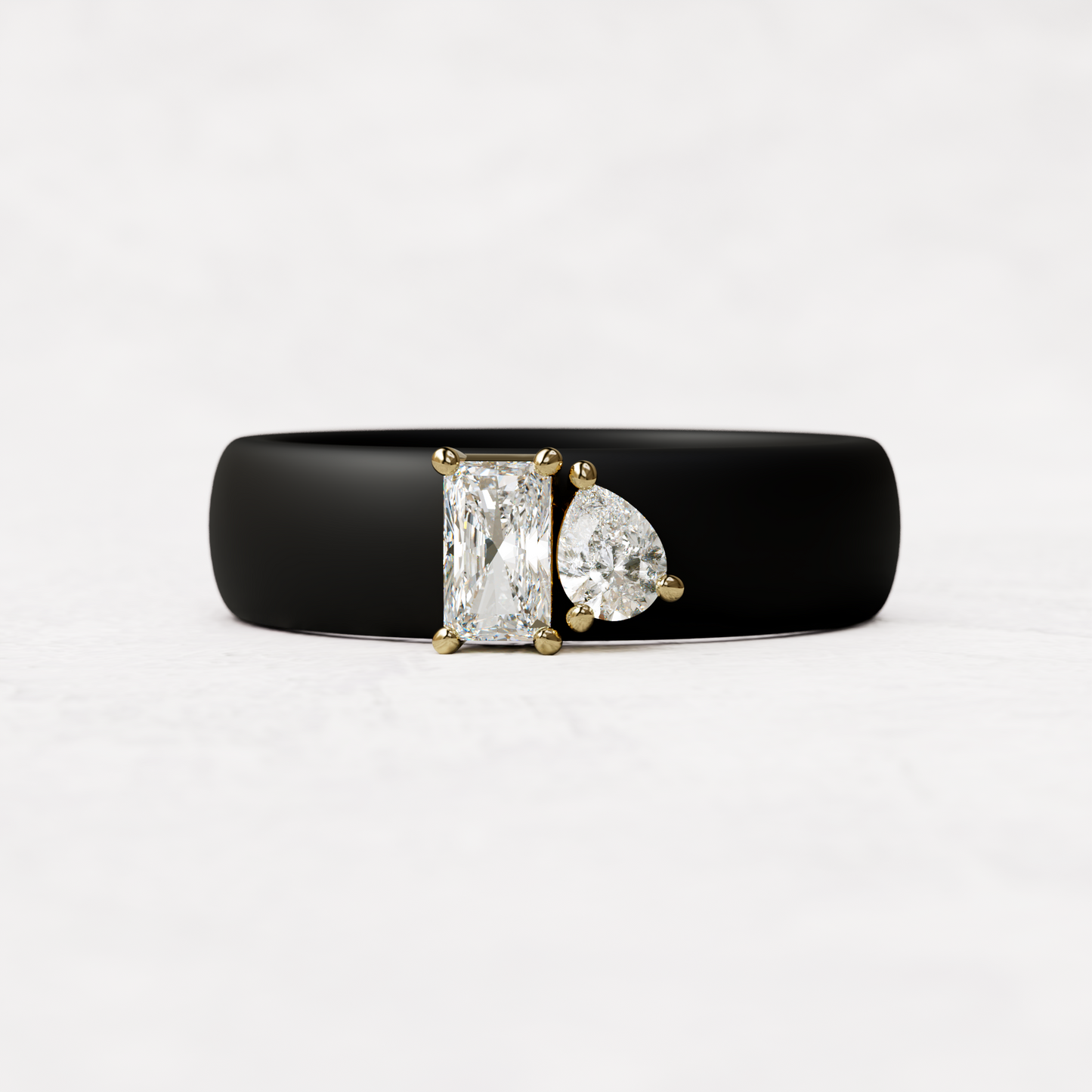 Black silicone diamond toi et moi ring with one radiant diamond and one pear cut diamond set in 14 karat Gold 