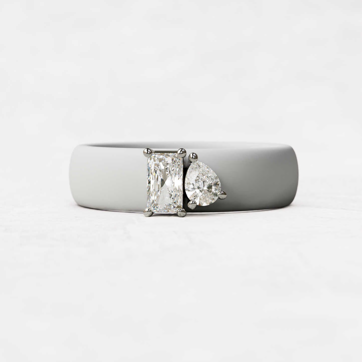 White silicone diamond toi et moi ring with one radiant diamond and one pear cut diamond set in 14 karat white Gold 